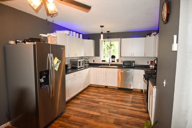 30400 Spruce Dr, Breezy Point, MN 56472 - kitchen with stainless steel appliances, dark wood-style flooring, white cabinetry, dark countertops, and a textured ceiling