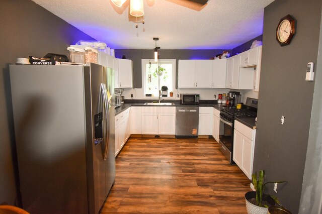 30400 Spruce Dr, Breezy Point, MN 56472 - kitchen with appliances with stainless steel finishes, a ceiling fan, dark countertops, dark wood-style flooring, and a textured ceiling