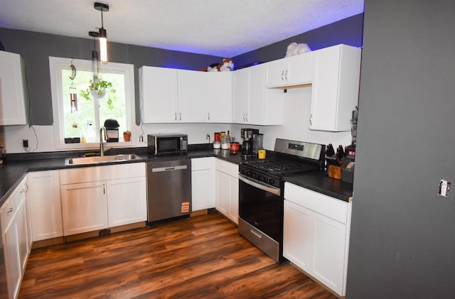30400 Spruce Dr, Breezy Point, MN 56472 - kitchen with stainless steel appliances, dark countertops, white cabinets, and dark wood-type flooring