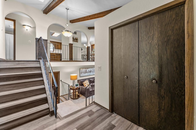 8409 Knollwood Dr, Mounds View, MN 55112 - entrance foyer featuring wood finished floors, beamed ceiling, arched walkways, and stairs