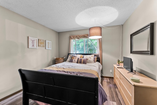 8409 Knollwood Dr, Mounds View, MN 55112 - bedroom featuring dark wood finished floors, a textured ceiling, and baseboards