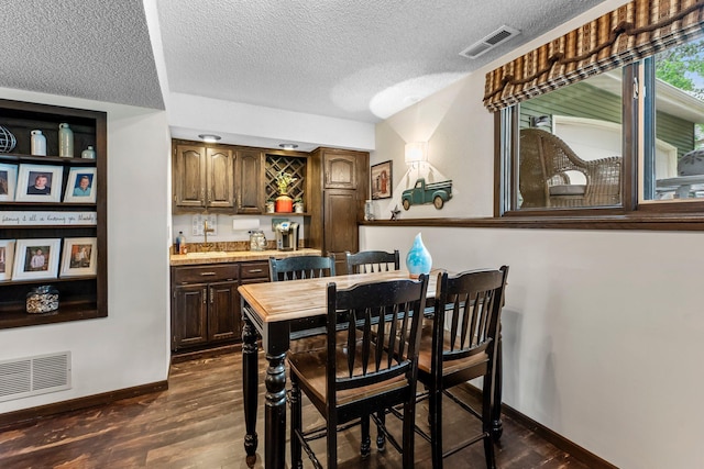 8409 Knollwood Dr, Mounds View, MN 55112 - dining space featuring wet bar, baseboards, dark wood finished floors, and a textured ceiling