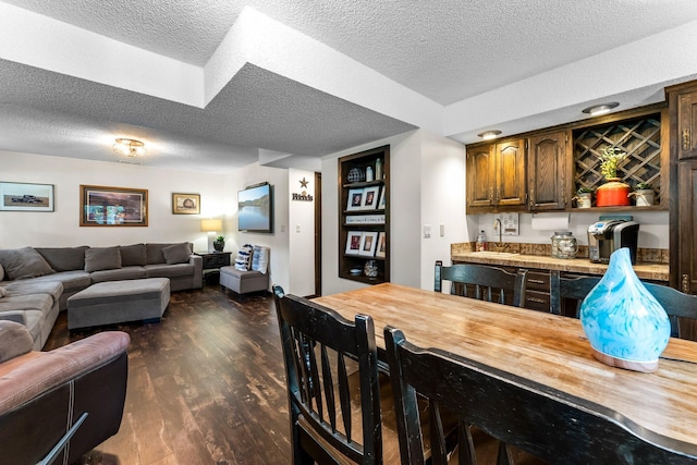 8409 Knollwood Dr, Mounds View, MN 55112 - kitchen featuring butcher block counters, open floor plan, a textured ceiling, dark wood finished floors, and a breakfast bar