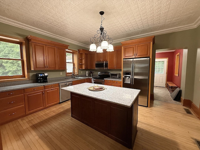 78994 160th St, Sacred Heart, MN 56285 - kitchen featuring appliances with stainless steel finishes, a sink, crown molding, a center island, and light wood-style floors