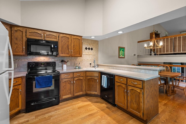 4540 Niagara Ln N, Plymouth, MN 55446 - kitchen with black appliances, a peninsula, a chandelier, brown cabinets, and a towering ceiling
