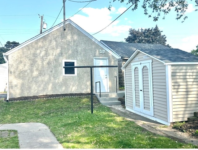 1368 Dale St N, Saint Paul, MN 55117 - exterior space with a storage unit, a yard, and a shingled roof