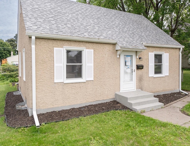 1368 Dale St N, Saint Paul, MN 55117 - view of front facade with roof with shingles, stucco siding, and a front lawn