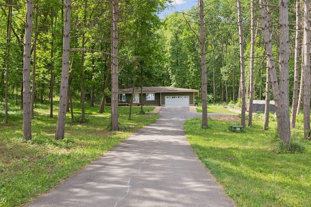 303 Cove Rd, Troy Twp, WI 54016 - ranch-style home with asphalt driveway, a view of trees, a garage, and a front yard