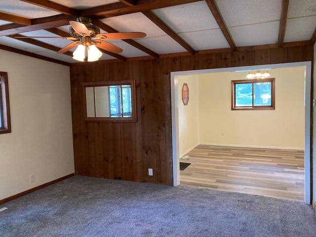643 Miller Ave, Windom, MN 56101 - empty room featuring wooden walls, beamed ceiling, a ceiling fan, carpet, and baseboards