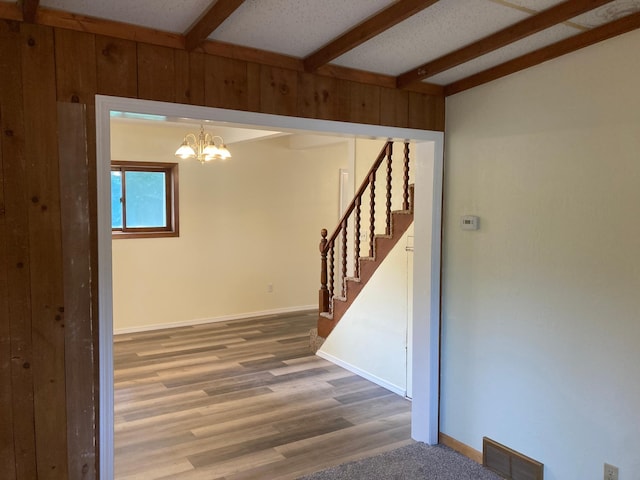 643 Miller Ave, Windom, MN 56101 - spare room with beam ceiling, a chandelier, stairs, wood finished floors, and baseboards