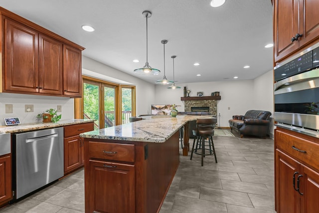 11960 Albavar Path, Inver Grove Heights, MN 55077 - kitchen with appliances with stainless steel finishes, open floor plan, a kitchen breakfast bar, light stone counters, and a brick fireplace