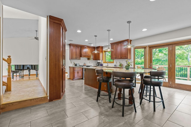 11960 Albavar Path, Inver Grove Heights, MN 55077 - kitchen with recessed lighting, brown cabinets, light stone countertops, a kitchen breakfast bar, and pendant lighting