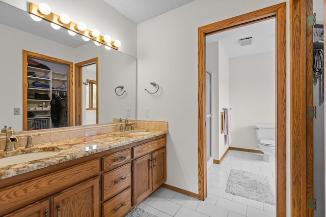 11960 Albavar Path, Inver Grove Heights, MN 55077 - bathroom with double vanity, a spacious closet, toilet, and tile patterned floors