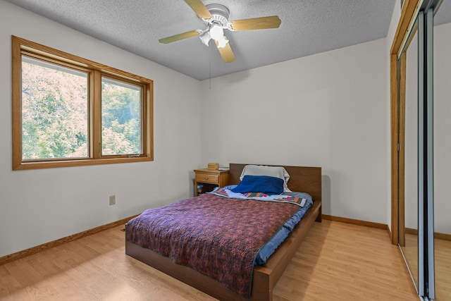 11960 Albavar Path, Inver Grove Heights, MN 55077 - bedroom featuring light wood-style floors, a textured ceiling, baseboards, ceiling fan, and a closet