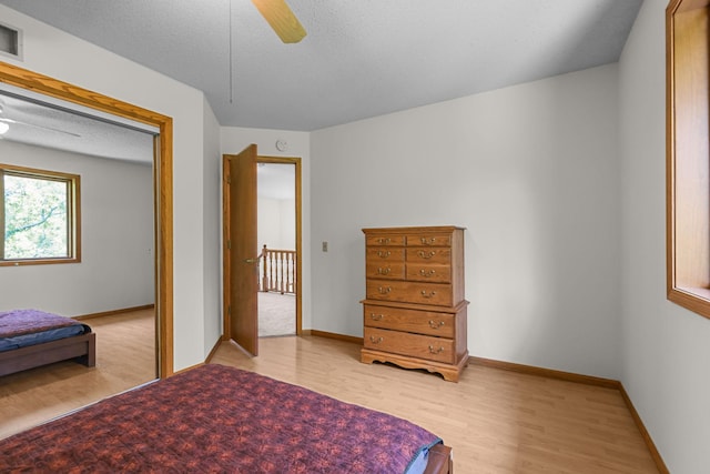 11960 Albavar Path, Inver Grove Heights, MN 55077 - bedroom with light wood-type flooring, baseboards, a textured ceiling, and a ceiling fan