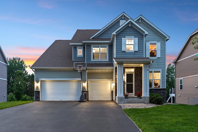 18482 Aubrie Ct, Eden Prairie, MN 55347 - craftsman-style house featuring driveway, stone siding, a yard, a shingled roof, and a garage