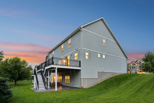 18482 Aubrie Ct, Eden Prairie, MN 55347 - back of house at dusk with stairway, a lawn, a wooden deck, and a patio area