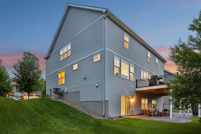 18482 Aubrie Ct, Eden Prairie, MN 55347 - back of property at dusk featuring a lawn and a patio area