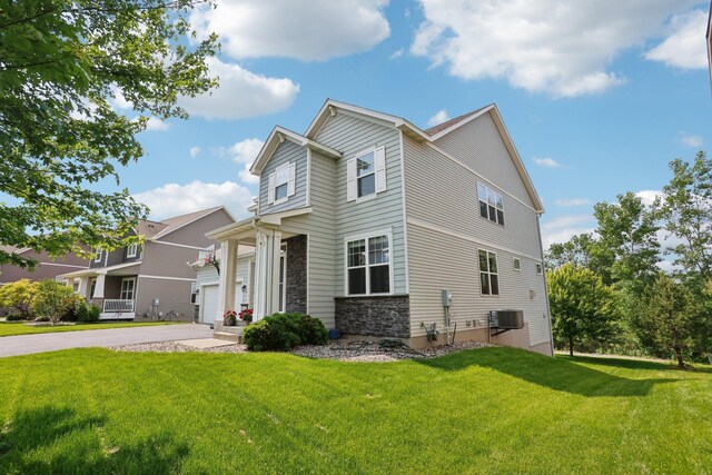 18482 Aubrie Ct, Eden Prairie, MN 55347 - view of front of house with stone siding, a front yard, and driveway