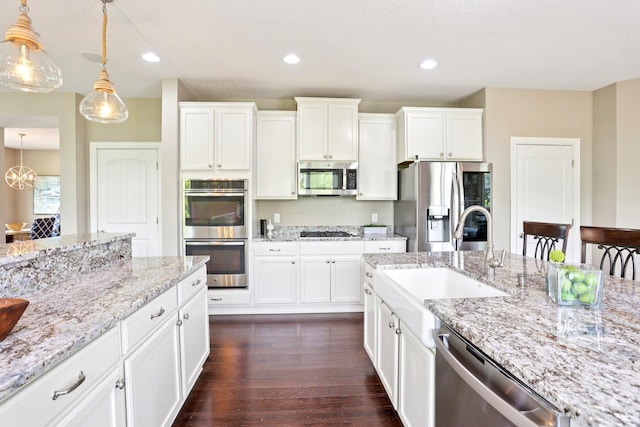 18482 Aubrie Ct, Eden Prairie, MN 55347 - kitchen with appliances with stainless steel finishes, dark wood finished floors, white cabinetry, decorative light fixtures, and recessed lighting