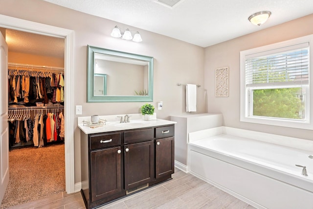 18482 Aubrie Ct, Eden Prairie, MN 55347 - full bathroom featuring vanity, a bath, wood finish floors, and a walk in closet
