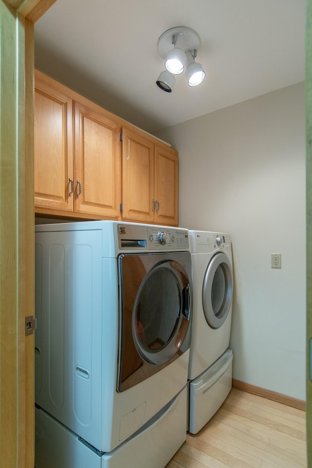 27488 Ridgewood Dr, Merrifield, MN 56465 - washroom featuring cabinet space, independent washer and dryer, light wood finished floors, and baseboards