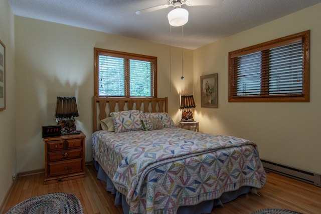27488 Ridgewood Dr, Merrifield, MN 56465 - bedroom with a baseboard radiator, wood finished floors, and a ceiling fan