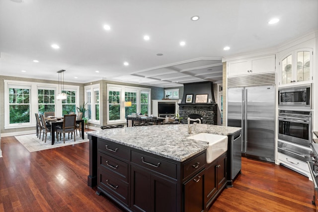 1501 June Ave S, Golden Valley, MN 55416 - kitchen with built in appliances, a warming drawer, white cabinets, light stone countertops, and a kitchen island with sink