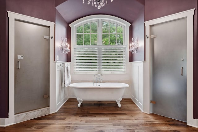 1501 June Ave S, Golden Valley, MN 55416 - bathroom featuring wood finished floors, plenty of natural light, a freestanding bath, wainscoting, and a chandelier