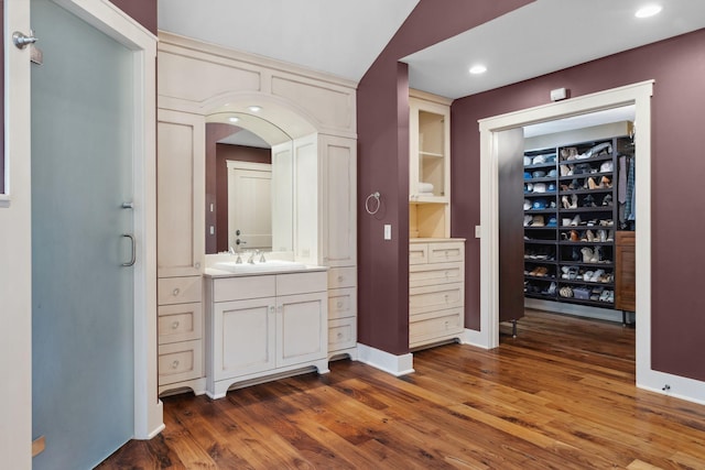 1501 June Ave S, Golden Valley, MN 55416 - bathroom with vanity, wood finished floors, a walk in closet, and recessed lighting