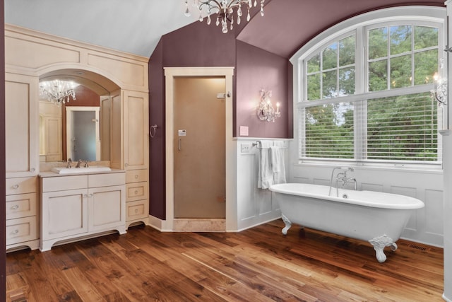 1501 June Ave S, Golden Valley, MN 55416 - bathroom with a chandelier, a freestanding bath, vanity, lofted ceiling, and wood finished floors
