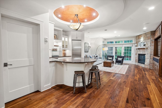 1501 June Ave S, Golden Valley, MN 55416 - kitchen featuring dark wood-style floors, built in refrigerator, a raised ceiling, a breakfast bar area, and recessed lighting