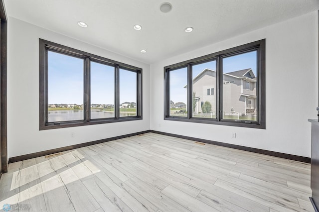 3004 6th St E, West Fargo, ND 58078 - empty room with baseboards, recessed lighting, light wood finished floors, and a water view