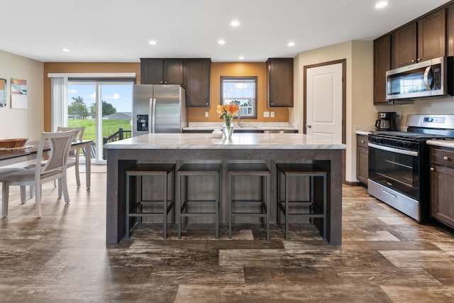 16536 Hook Cir, Pokegama Twp, MN 55030 - kitchen featuring stainless steel appliances, dark brown cabinets, a kitchen island, recessed lighting, and healthy amount of natural light