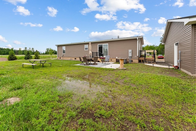 16536 Hook Cir, Pokegama Twp, MN 55030 - rear view of house featuring a deck, a patio area, and a lawn