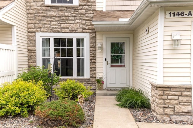 1146 100th Dr NE Unit A, Blaine, MN 55434 - view of exterior entry featuring stone siding and a shingled roof
