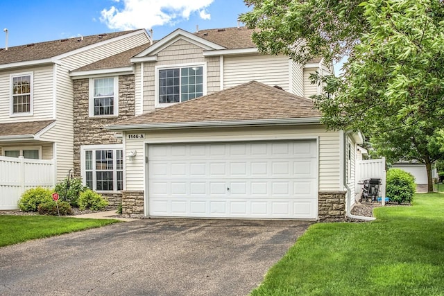 1146 100th Dr NE Unit A, Blaine, MN 55434 - view of front of property with stone siding, driveway, a shingled roof, a front yard, and an attached garage