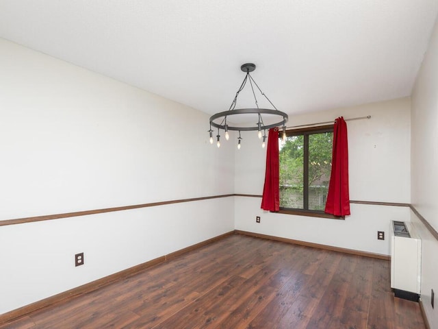 2200 Nevada Ave S Unit 206, Saint Louis Park, MN 55426 - empty room with a chandelier, wood finished floors, baseboards, and radiator