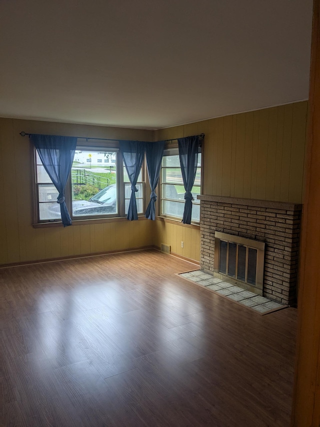 1193 County Road B E, Maplewood, MN 55109 - unfurnished living room featuring wood finished floors, a brick fireplace, and wood walls