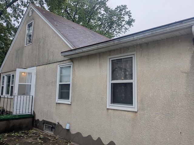 1193 County Road B E, Maplewood, MN 55109 - view of property exterior with stucco siding and roof with shingles
