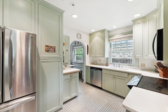 1913 River Pkwy, Minneapolis, MN 55414 - kitchen with stainless steel appliances, green cabinets, light countertops, arched walkways, and recessed lighting