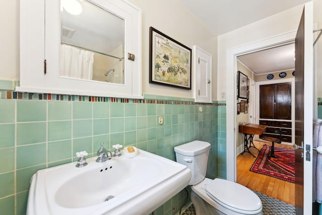 1913 River Pkwy, Minneapolis, MN 55414 - full bath featuring tile walls, wood finished floors, a shower with curtain, and wainscoting