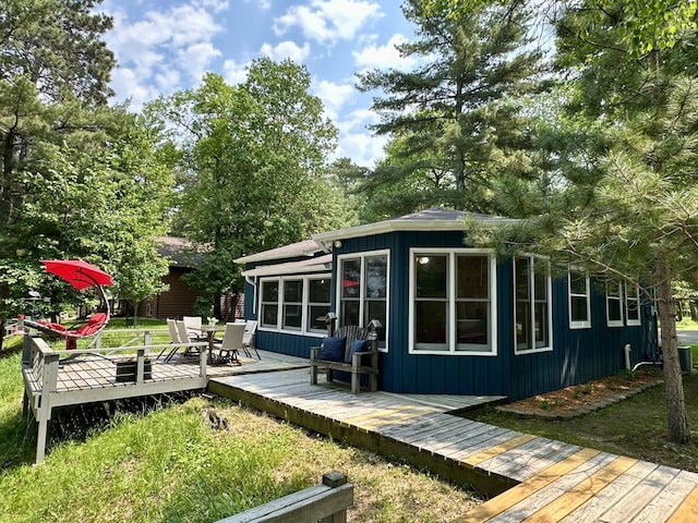 12332 Manhattan Point Blvd, Crosslake, MN 56442 - back of house with board and batten siding, a deck, and outdoor dining area