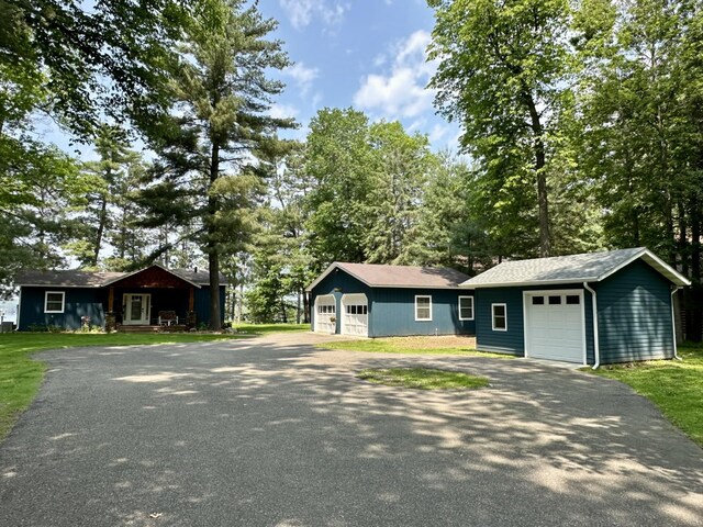 12332 Manhattan Point Blvd, Crosslake, MN 56442 - ranch-style home with a garage, an outbuilding, asphalt driveway, and view of scattered trees