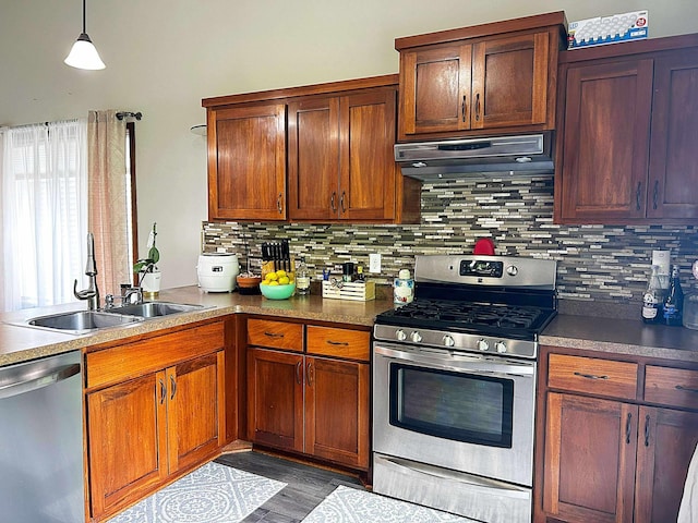 12383 Midway Cir NE, Blaine, MN 55449 - kitchen featuring appliances with stainless steel finishes, under cabinet range hood, tasteful backsplash, hanging light fixtures, and dark wood finished floors