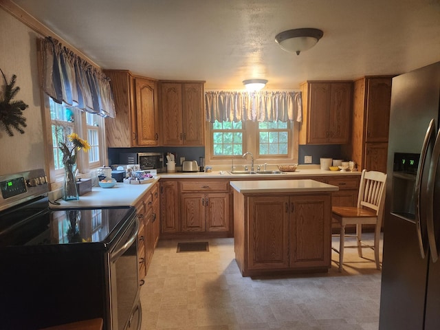23064 Pearl Lake Rd, Lake View Twp, MN 56501 - kitchen with stainless steel appliances, light countertops, brown cabinets, a sink, and a kitchen island