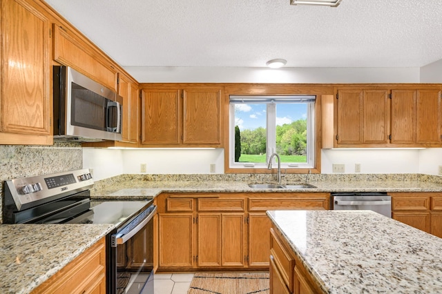 3924 Denmark Ave, Eagan, MN 55123 - kitchen with appliances with stainless steel finishes, a sink, brown cabinets, and a textured ceiling