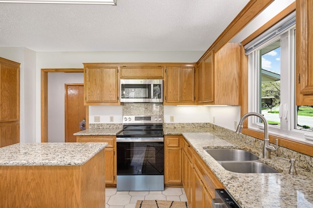 3924 Denmark Ave, Eagan, MN 55123 - kitchen featuring stainless steel appliances, a sink, light stone countertops, a textured ceiling, and light tile patterned floors