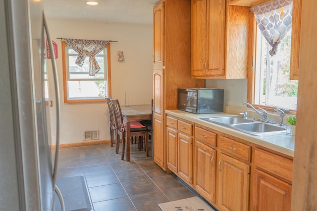 2161 Ross Ave E, Saint Paul, MN 55119 - kitchen featuring fridge, light countertops, dark tile patterned flooring, black microwave, and recessed lighting