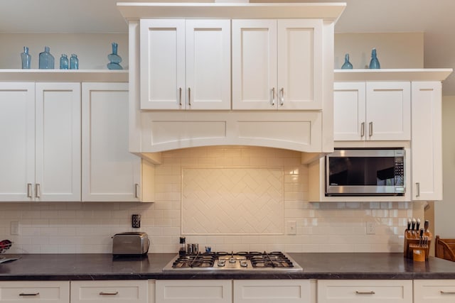 1614 8th St, Grand Rapids, MN 55744 - kitchen with stainless steel appliances, dark countertops, white cabinetry, and backsplash